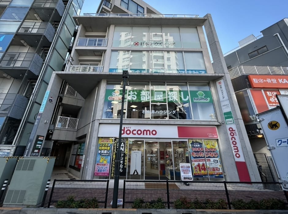 HSタワー2階にある石神井ハウジングの店舗外観、お部屋探しの看板やsuumoのロゴが見える