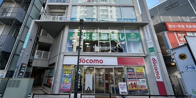 日本の都市部にある多層階の商業ビル。NTTドコモ店舗と不動産店舗が入る建物の外観